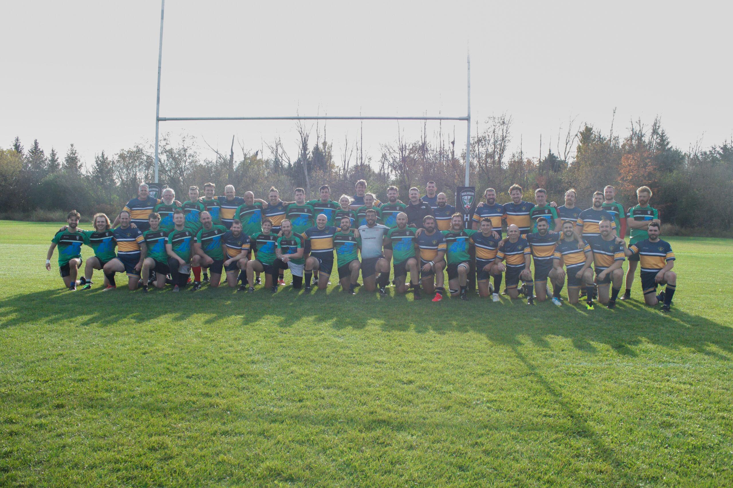 Two rugby squads together on the main pitch at Oakfield Park after a match